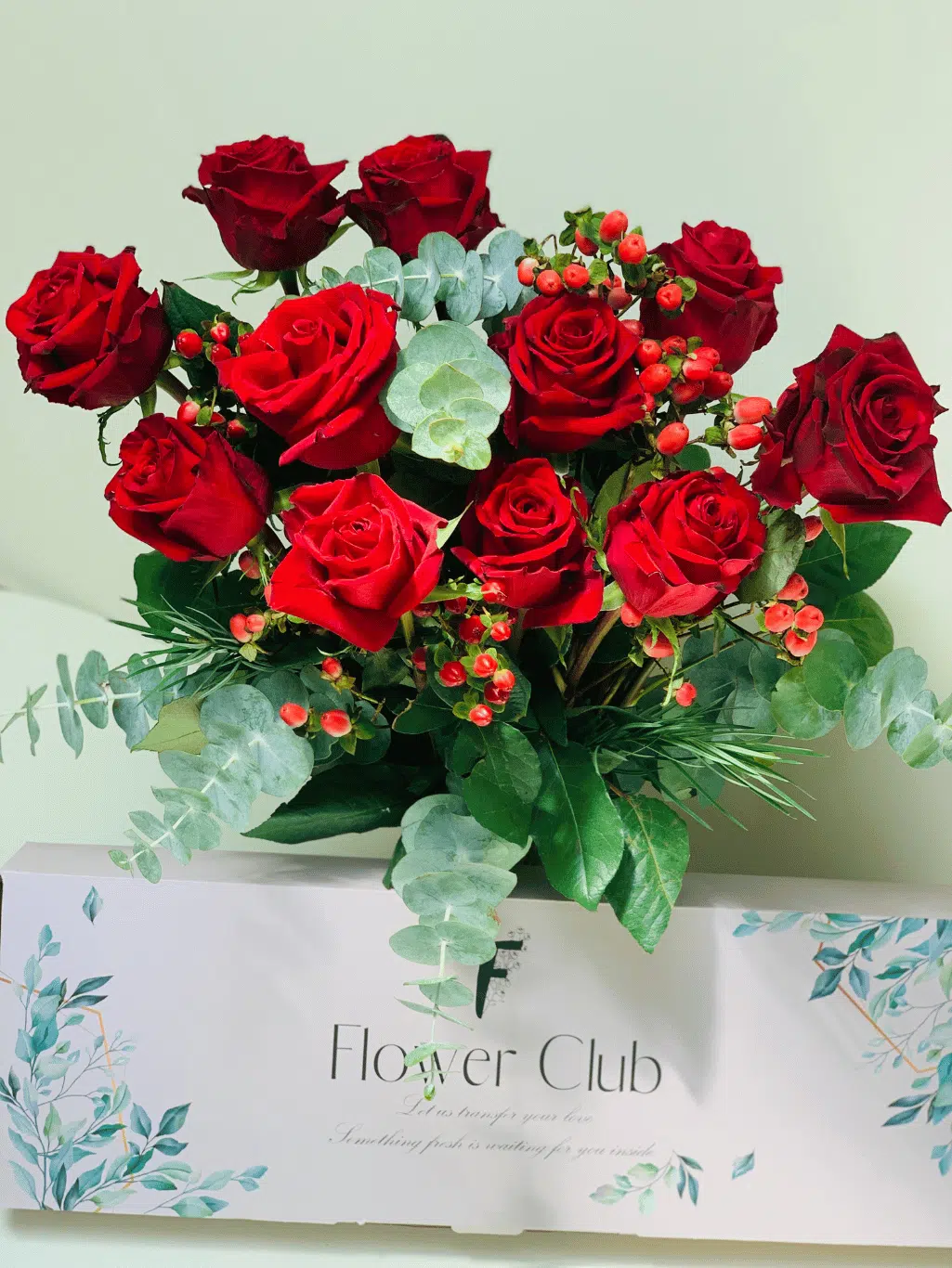 red roses with hypericums and gum leaves and flower club letterbox
