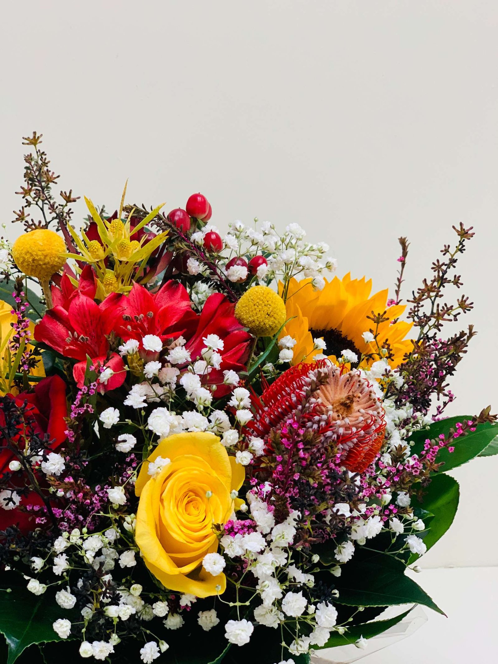 yellow and red flower arrangement in a vase