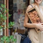 holding a boxed flower arrangement